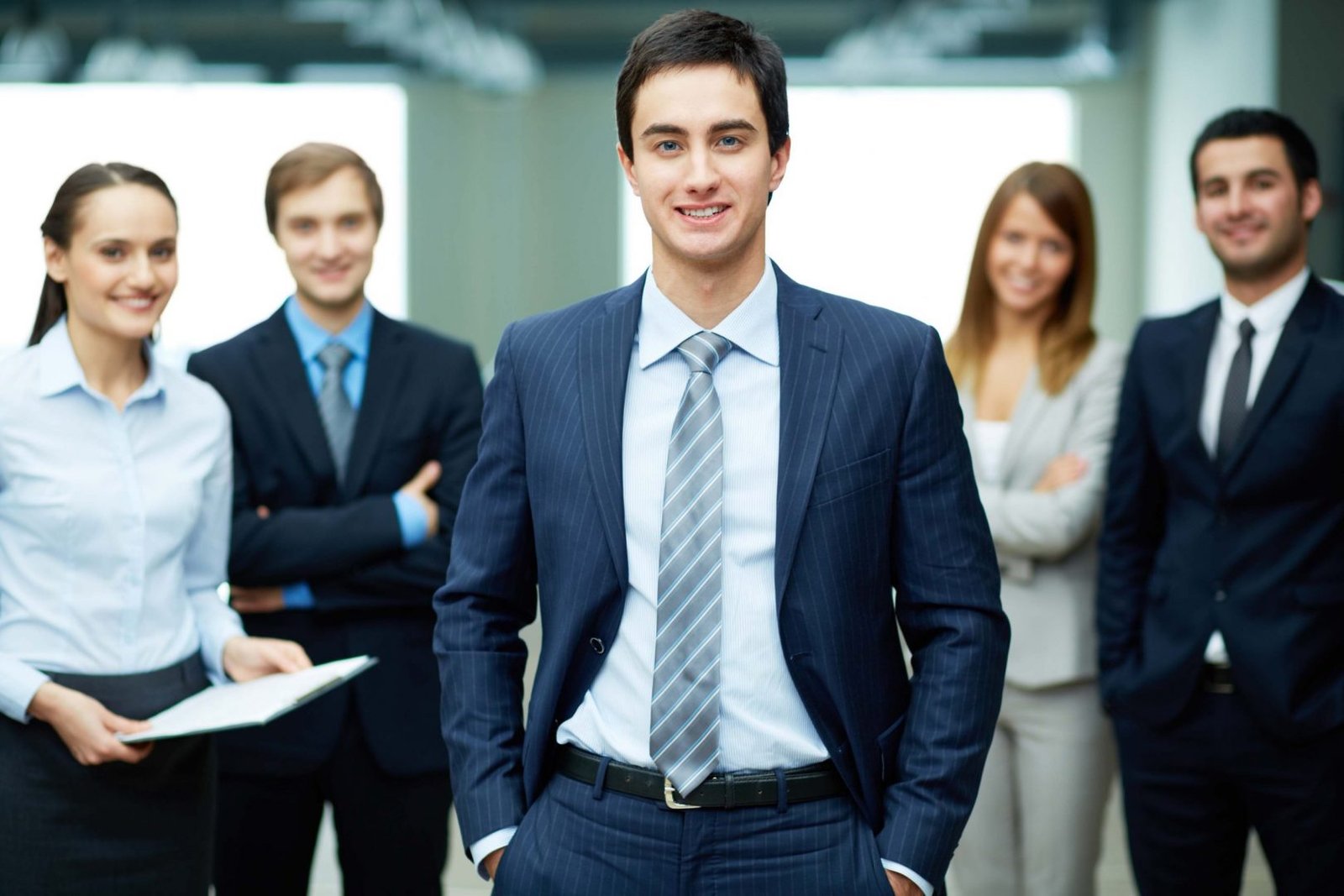 Group of friendly businesspeople with male leader in front